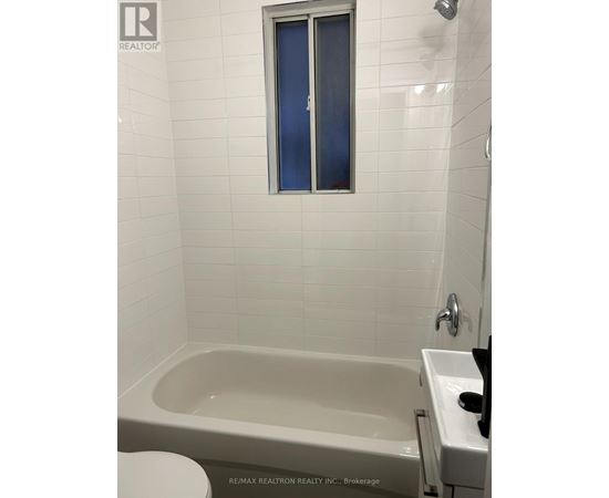 A white bathroom with a tub, toilet, and sink.