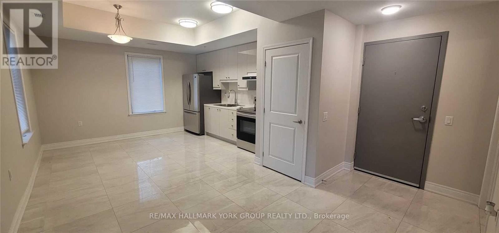 A spacious kitchen with white appliances and a white door.