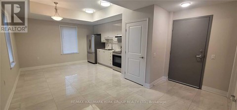 A spacious kitchen with white appliances and a white door.