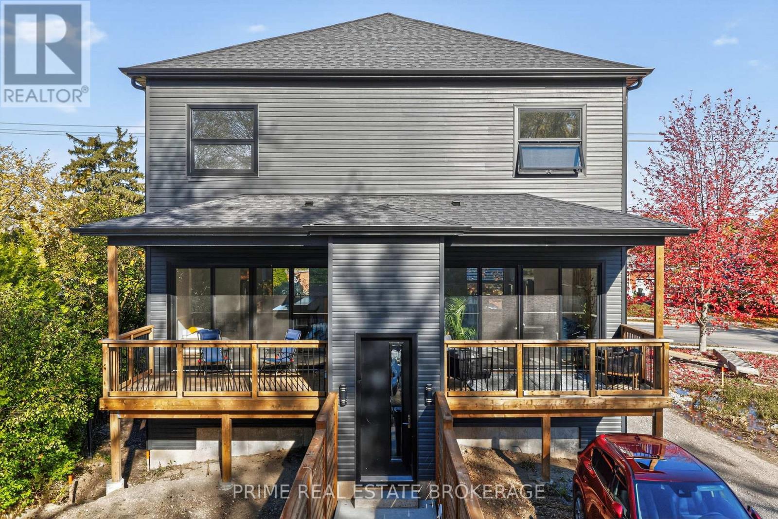 A house with a grey exterior and a balcony is for sale.