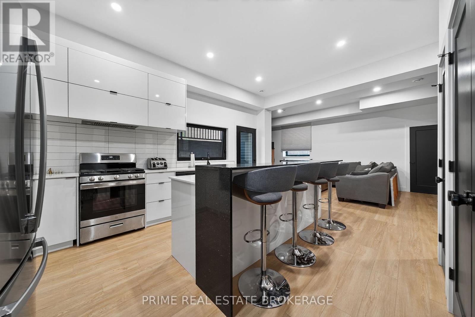A modern kitchen with a bar area and a refrigerator on the left.