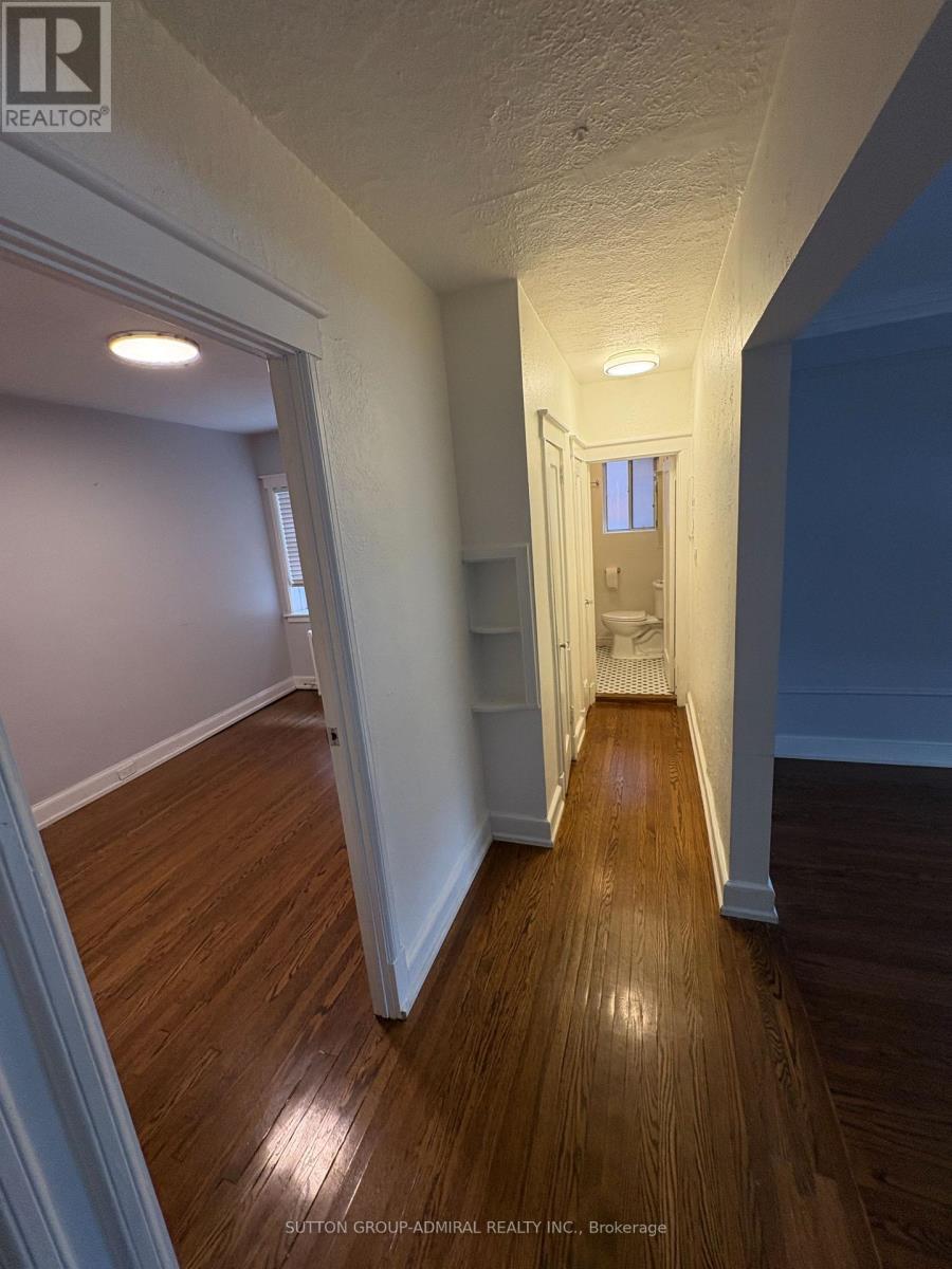 A hallway with wood floors and white walls.