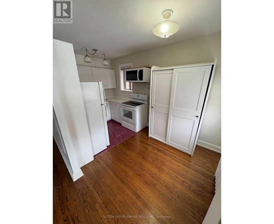 A kitchen with white appliances and cabinets.