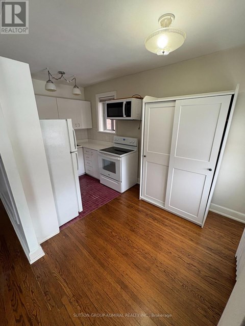 A kitchen with white appliances and cabinets.