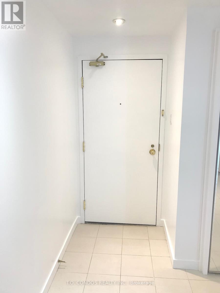 A white door in a room with a light switch on the wall.