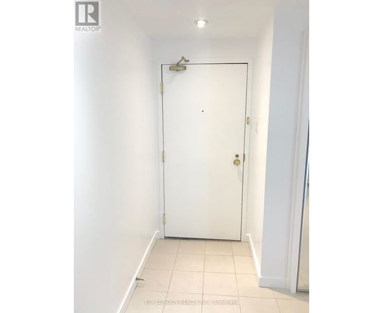 A white door in a room with a light switch on the wall.