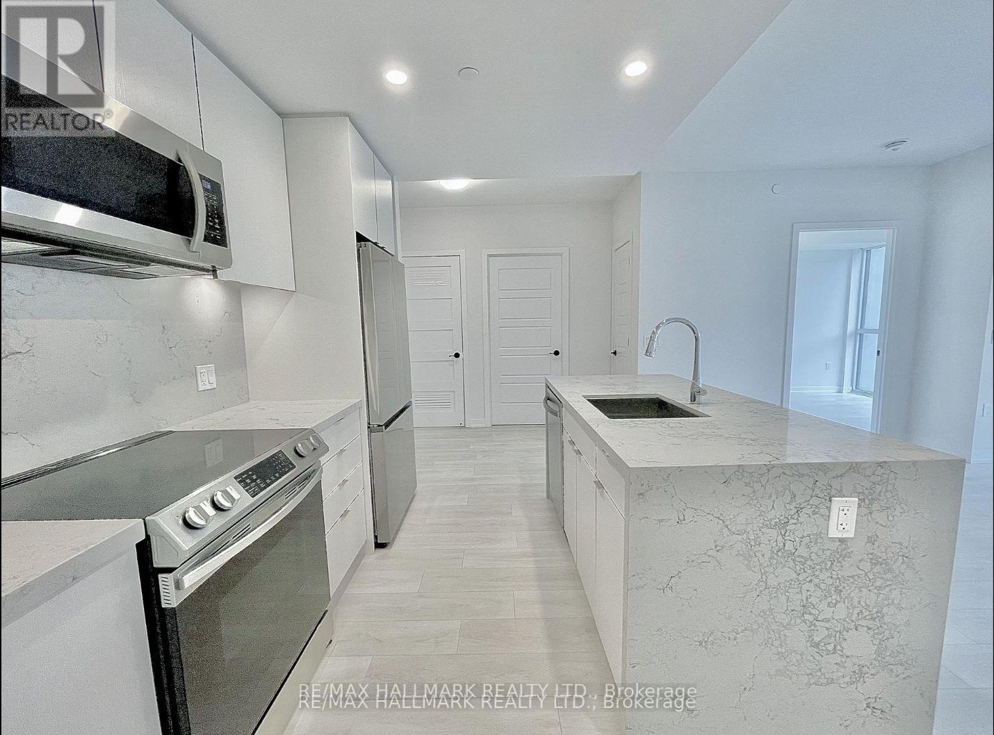 A modern kitchen with a stainless steel oven and a marble countertop.