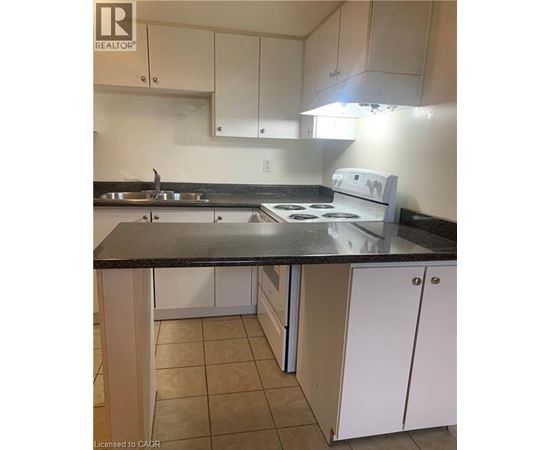 A kitchen with white cabinets and a black countertop.