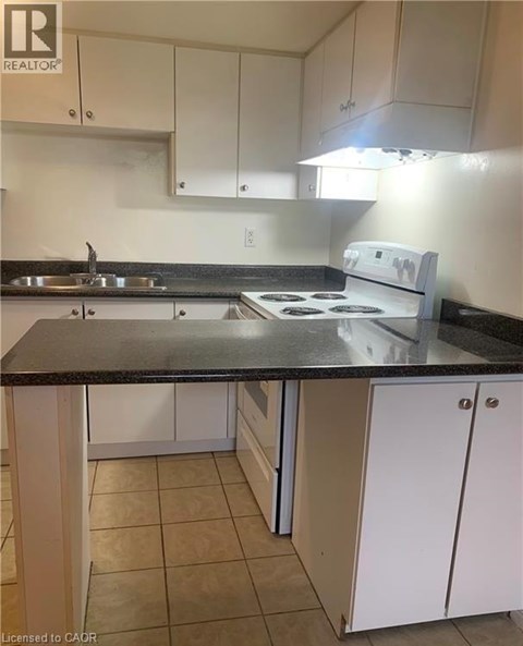 A kitchen with white cabinets and a black countertop.