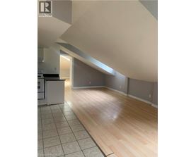 A kitchen with a white refrigerator and wooden floors.