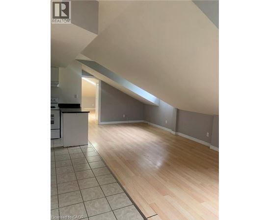 A kitchen with a white refrigerator and wooden floors.