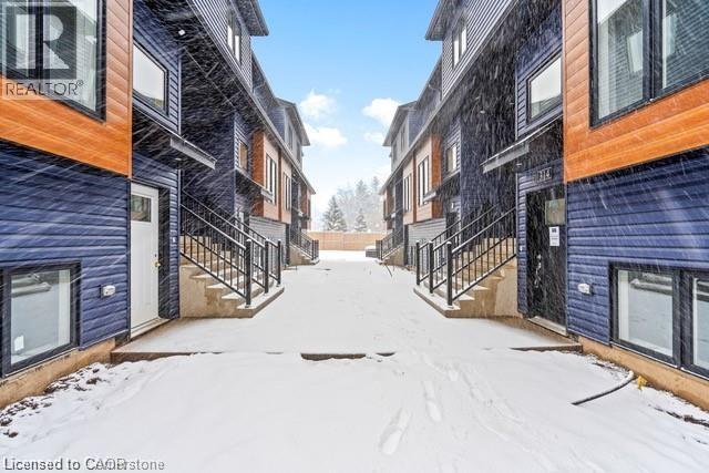 A snowy alley between two buildings with a REALTOR sign on the left building.