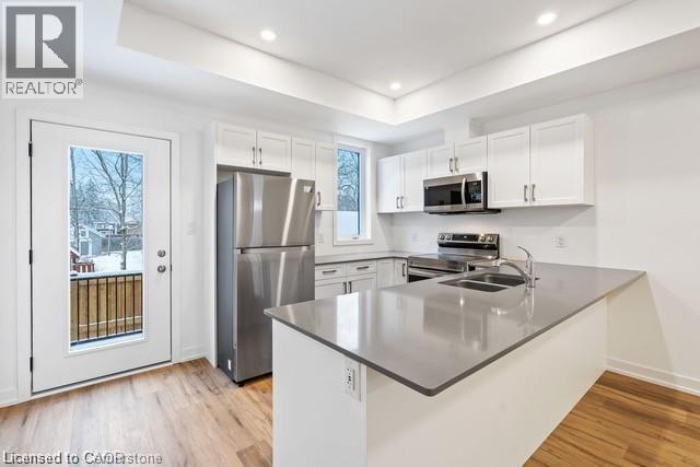 A kitchen with white cabinets and a grey countertop.