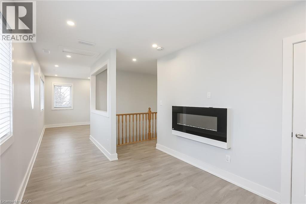 A spacious room with a fireplace and wooden flooring.