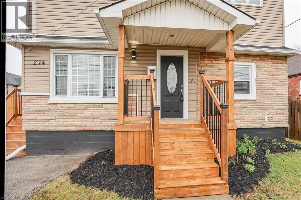 A house with a black door and a wooden staircase leading to the entrance.