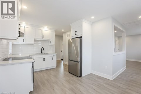 A modern kitchen with white cabinets and a refrigerator.