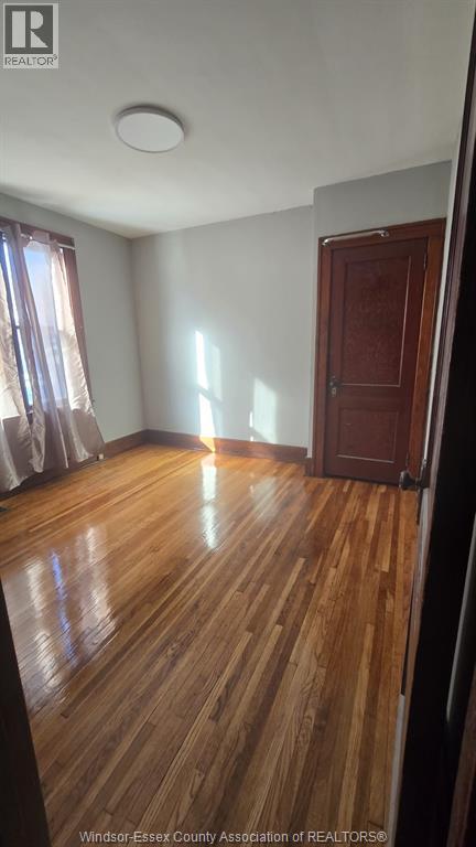 A room with wooden flooring and a closed door.