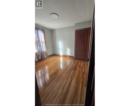 A room with wooden flooring and a closed door.