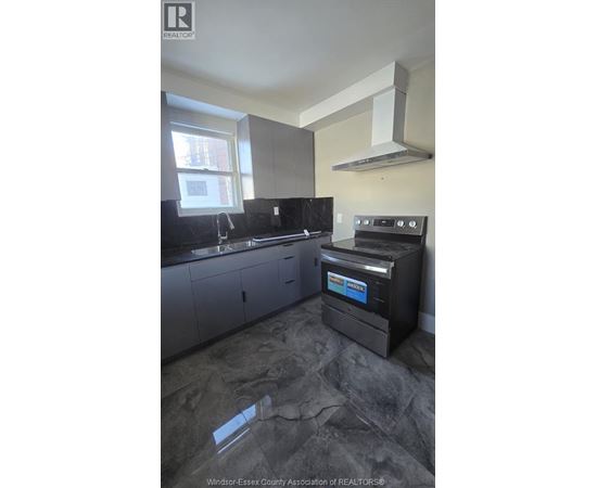 A kitchen with a black stove top oven.