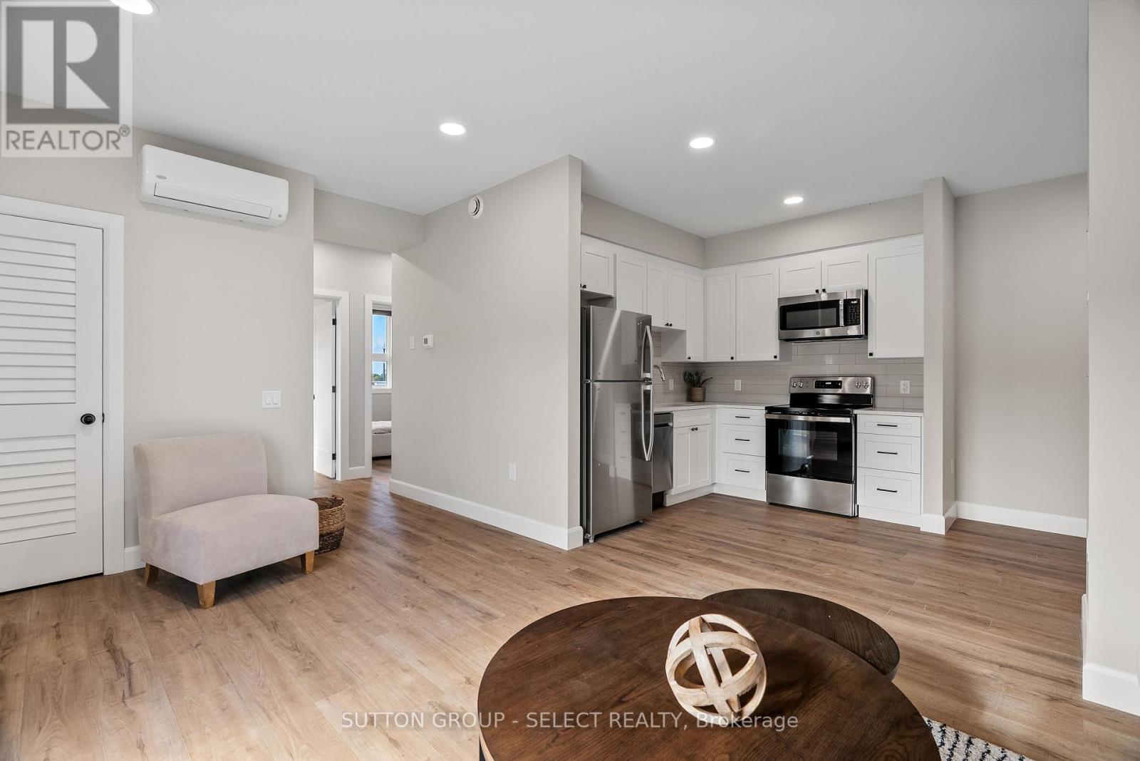A modern kitchen with a refrigerator, oven, and microwave.