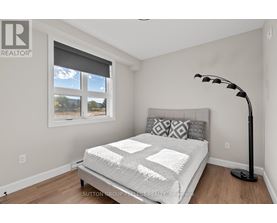 A bedroom with a large bed and a window with blinds.