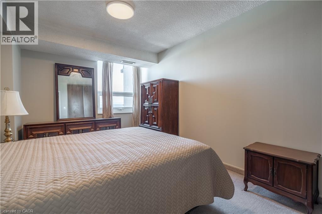 A bedroom with a large bed and a wooden dresser.