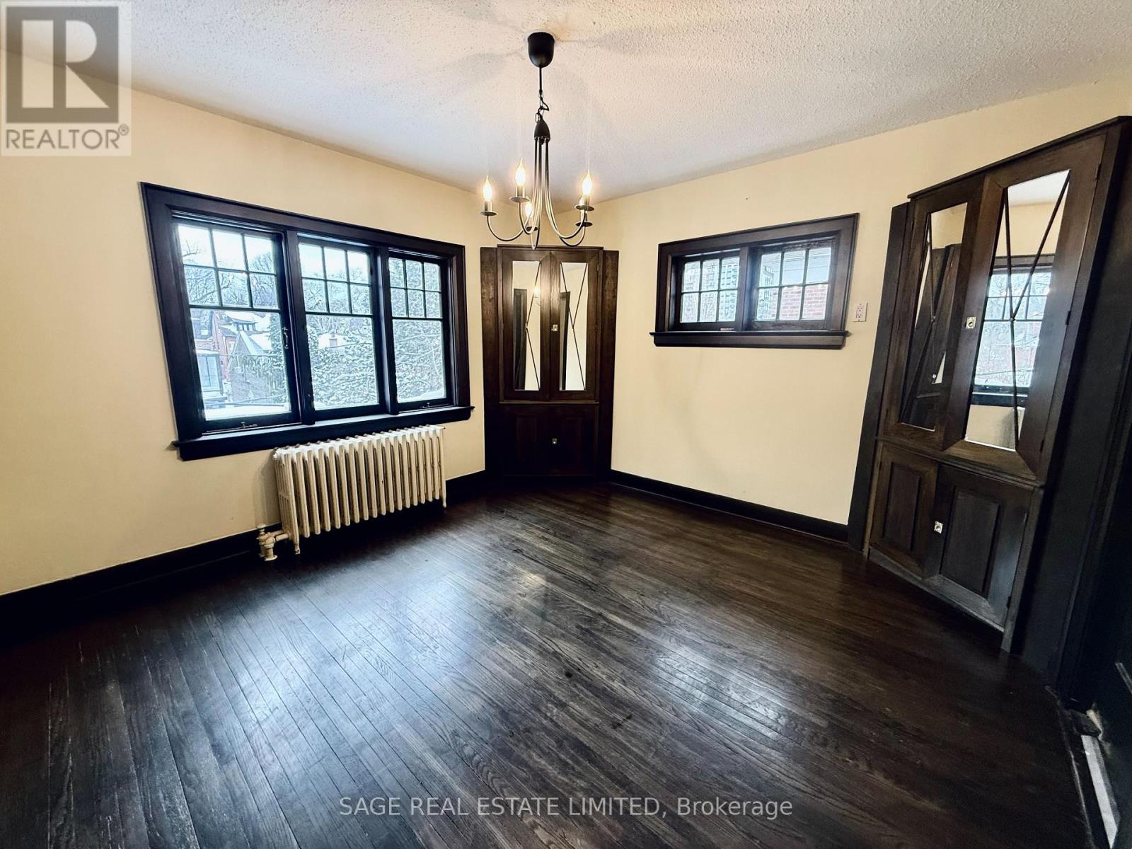 A room with wood floors and a chandelier.