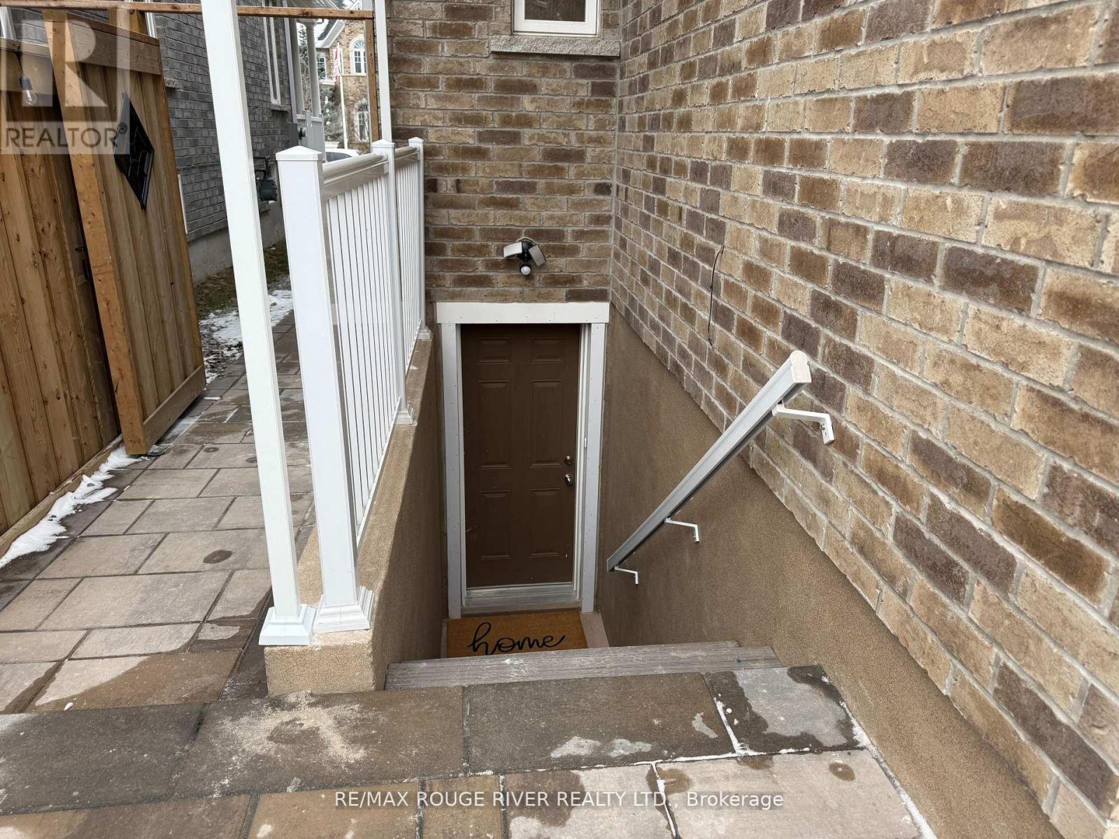 A small brown door is in a brick wall.