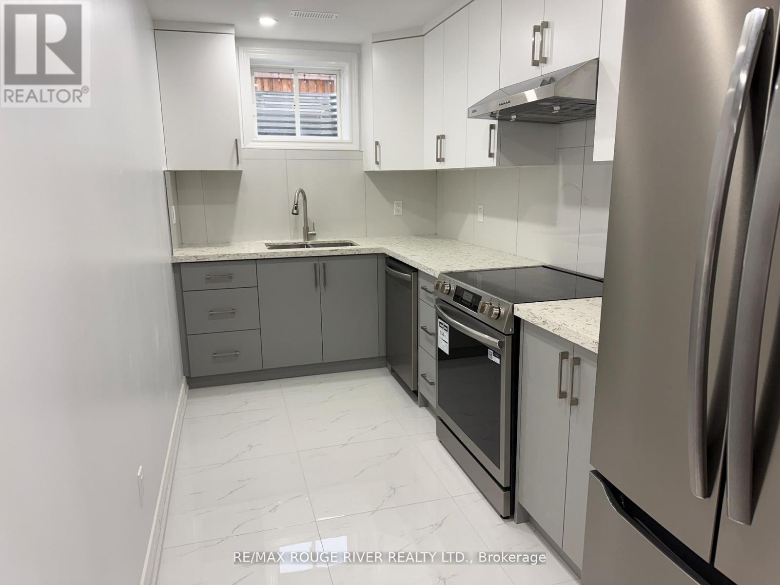 A kitchen with white cabinets and a stainless steel refrigerator.