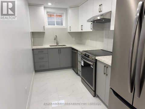 A kitchen with white cabinets and a stainless steel refrigerator.