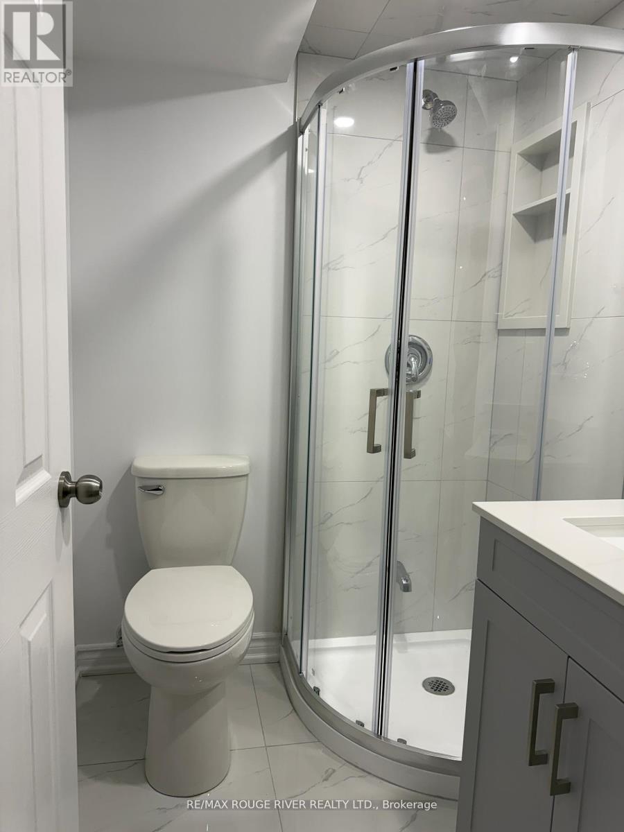 A white toilet in a bathroom with a glass shower door.