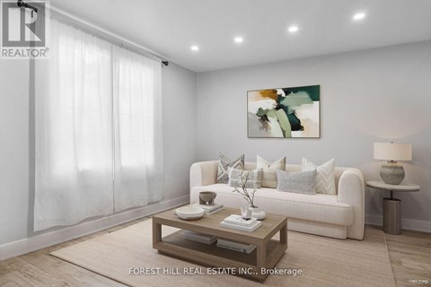 A living room with a white couch, a coffee table, and a painting on the wall.