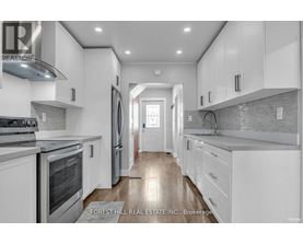 A modern kitchen with white cabinets and stainless steel appliances.