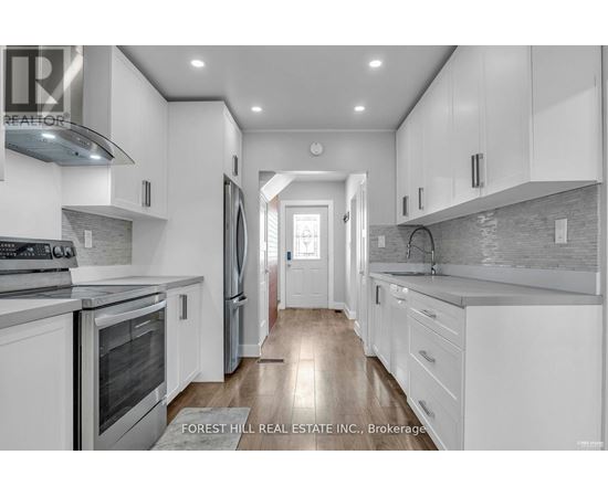 A modern kitchen with white cabinets and stainless steel appliances.
