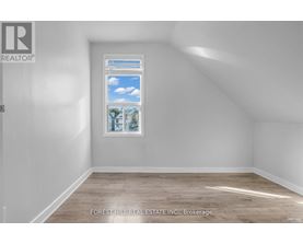 A room with a window showing a view of the sky and trees.
