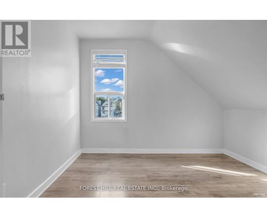 A room with a window showing a view of the sky and trees.