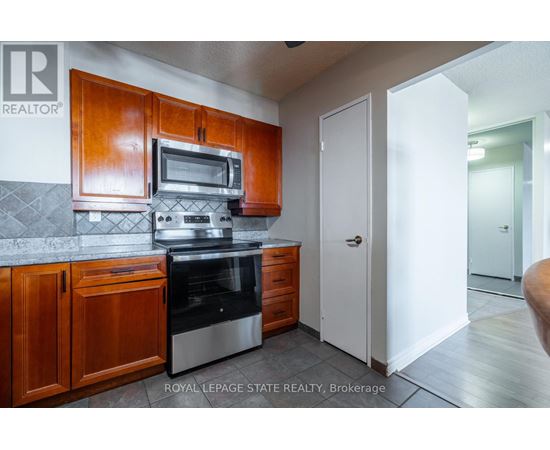 A kitchen with wooden cabinets and stainless steel appliances.