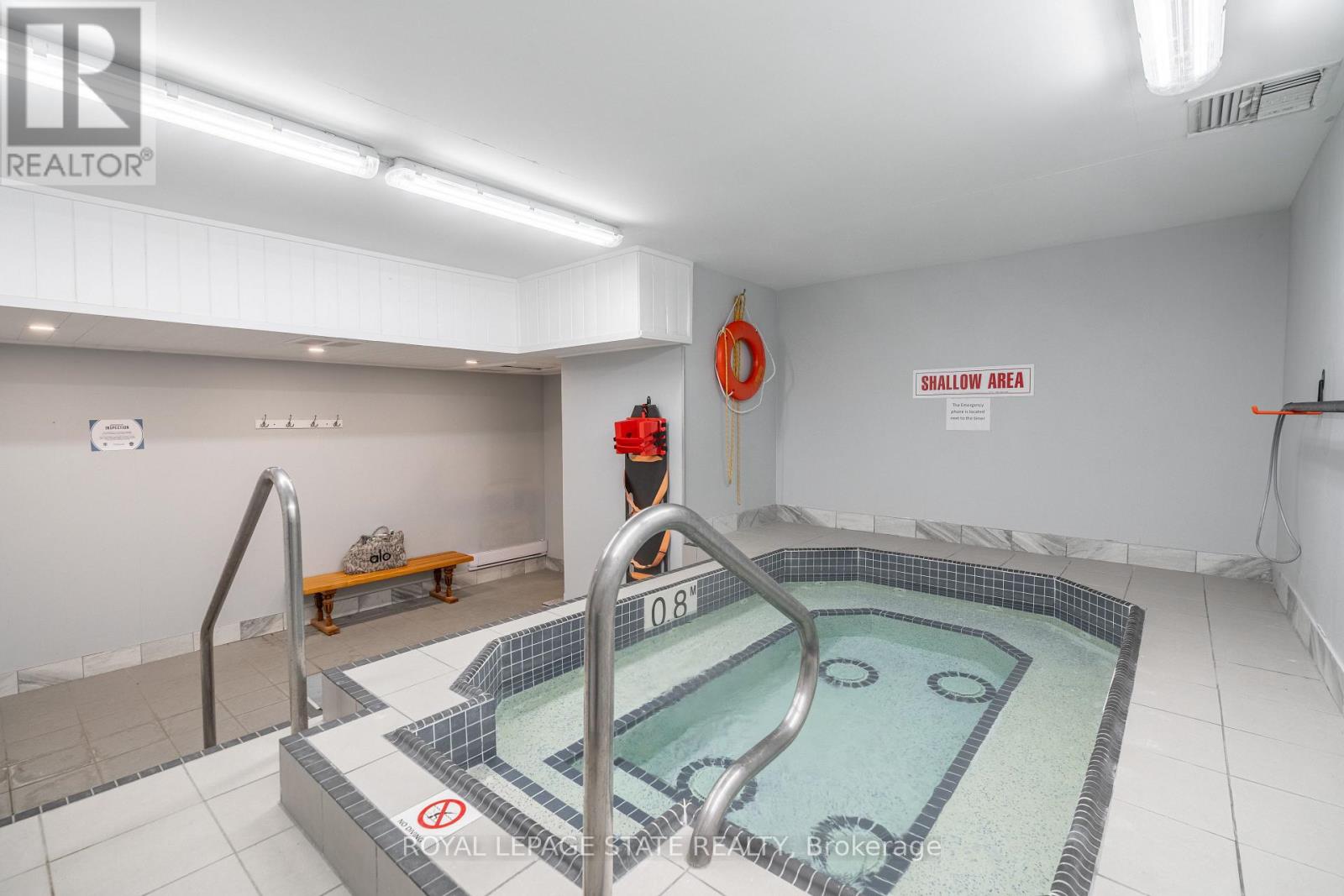 A swimming pool in a room with a sign that says "DANGER AREA".