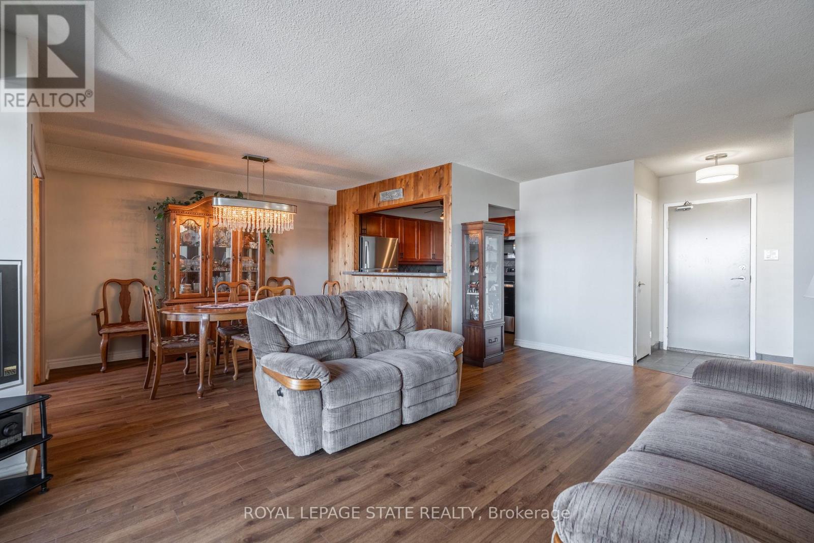 A living room with a grey couch and a wooden cabinet.