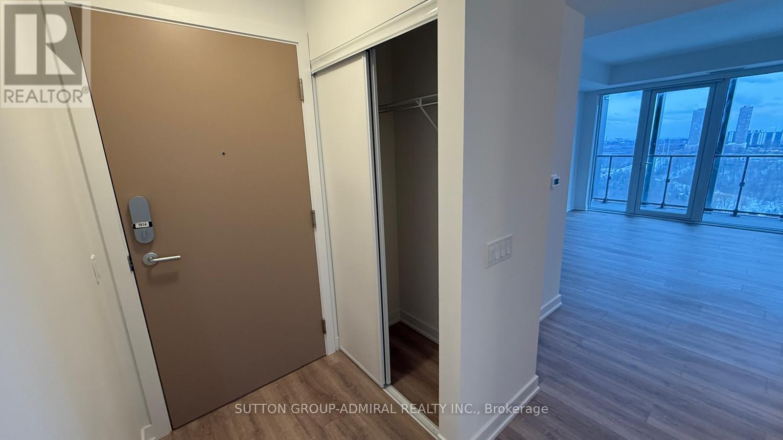A brown door with a handle and a lock is in a room with a white wall.