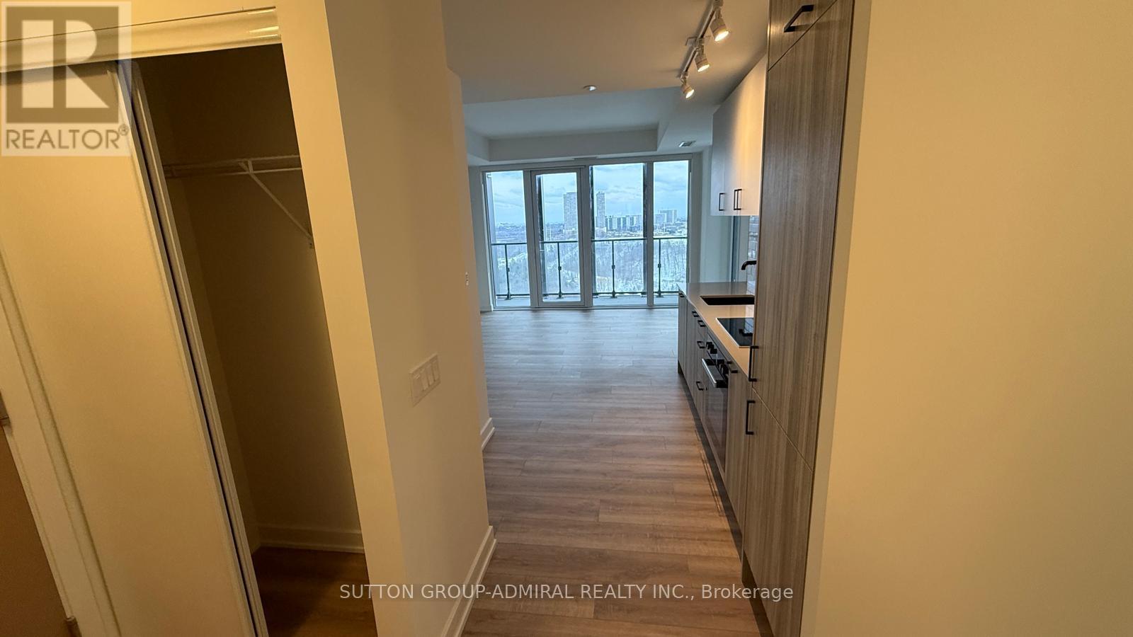 A hallway with a glass door leading to a balcony.