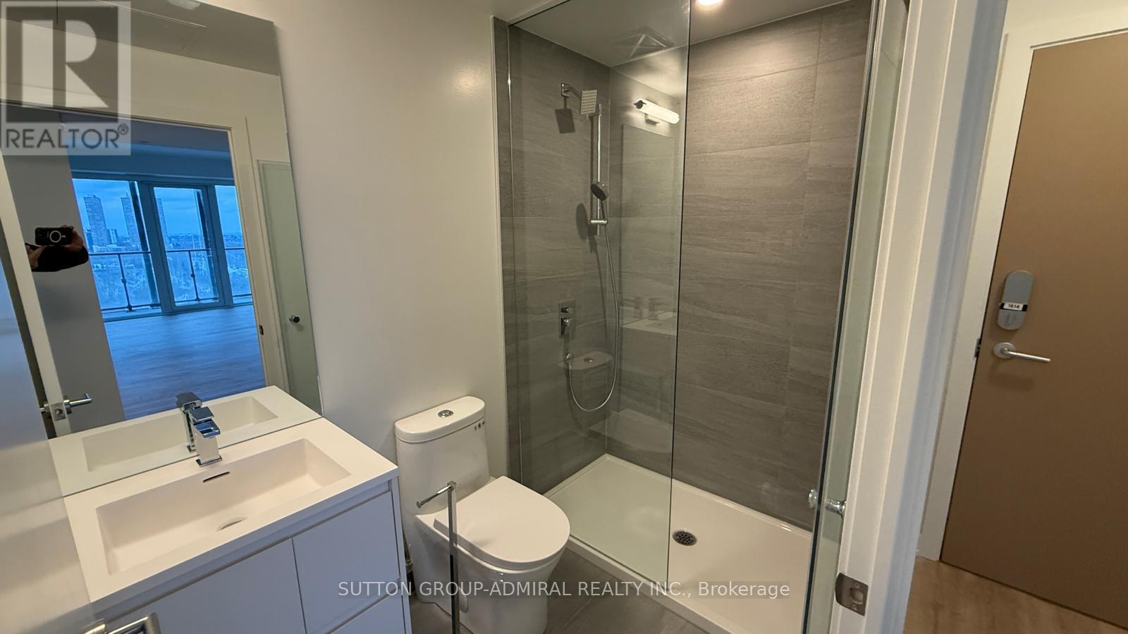 A bathroom with a sink, toilet, and shower.