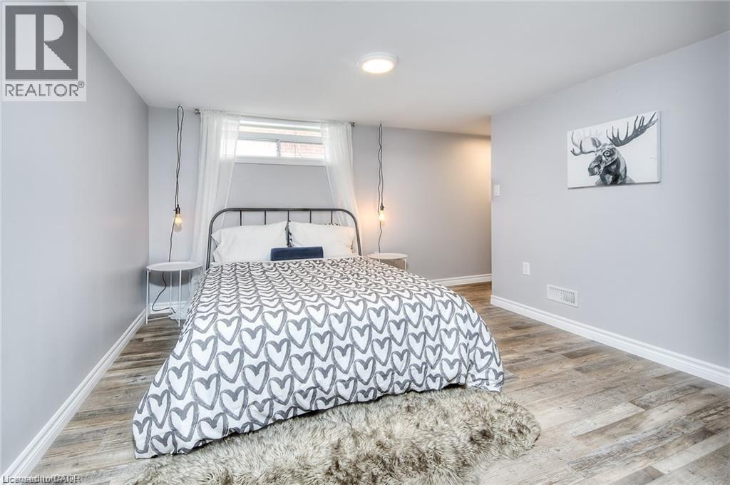 A bedroom with a bed, a rug, and a painting on the wall.