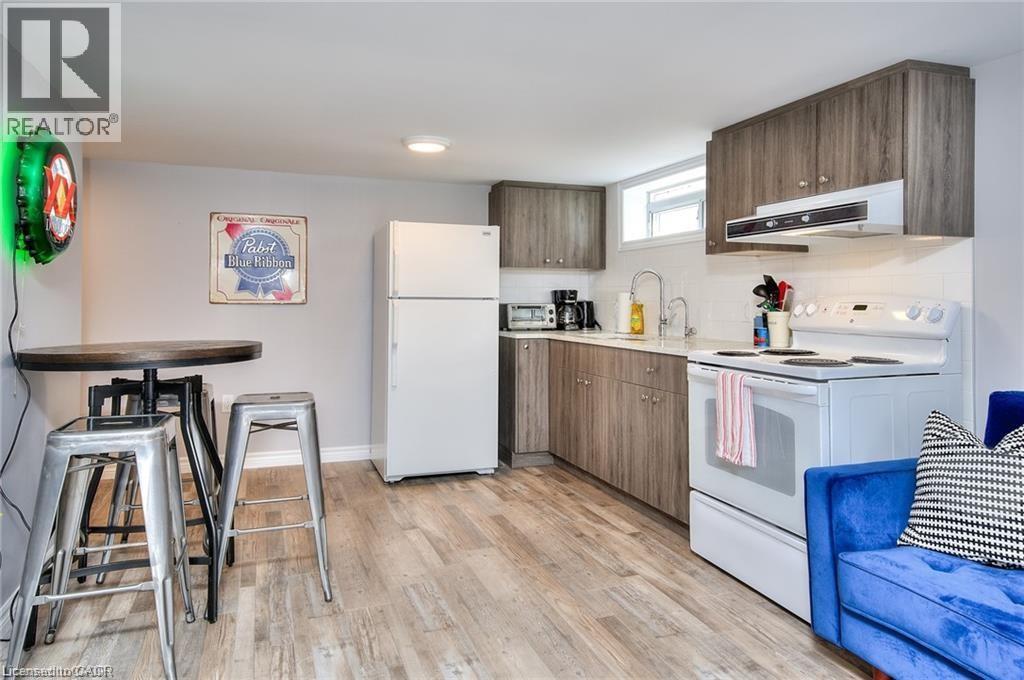 A kitchen with a white refrigerator, wooden cabinets, and a blue couch.