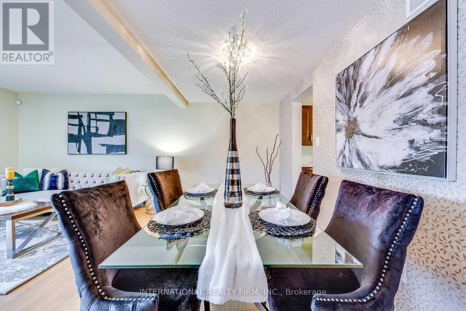 A dining room with a glass table and brown leather chairs.