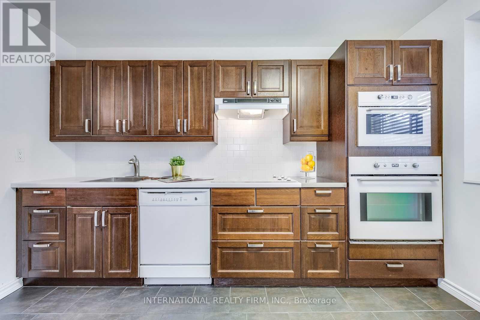 A kitchen with wooden cabinets and a white dishwasher.