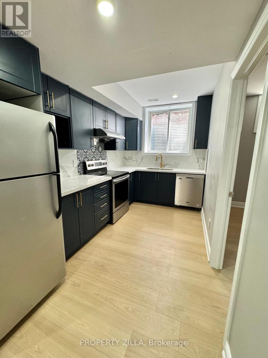 A kitchen with a refrigerator, cabinets, and a dishwasher.