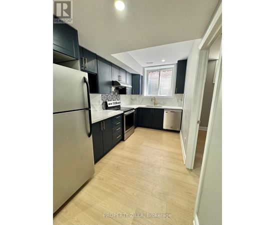 A kitchen with a refrigerator, cabinets, and a dishwasher.