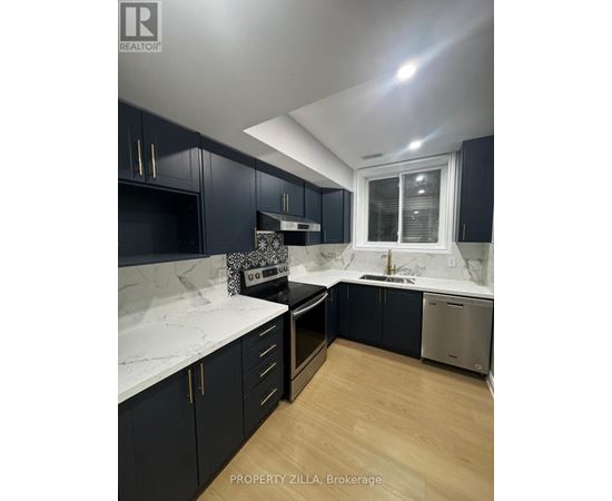 A kitchen with dark cabinets and a marble countertop.