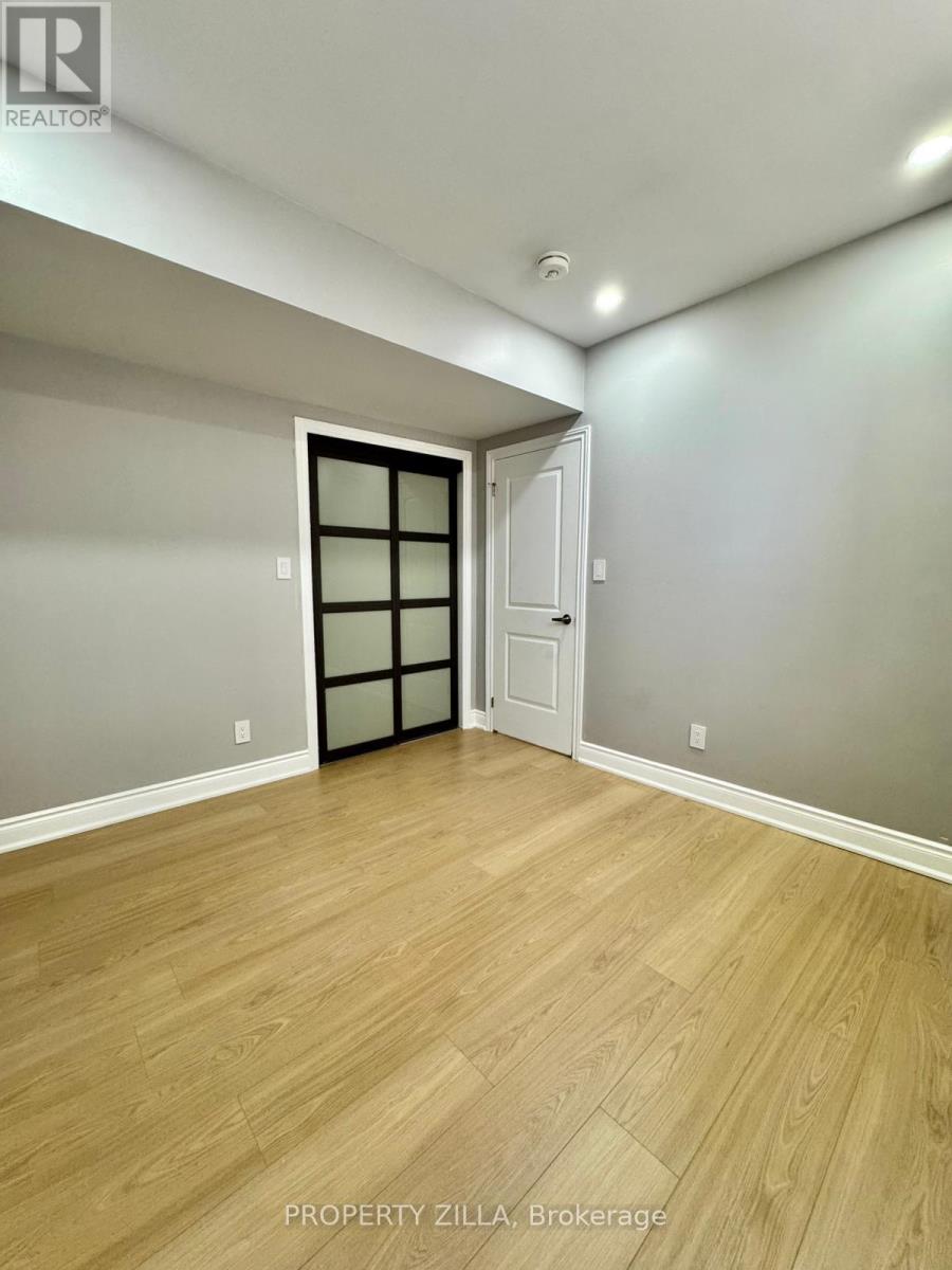 A room with wooden flooring and a door with a window.